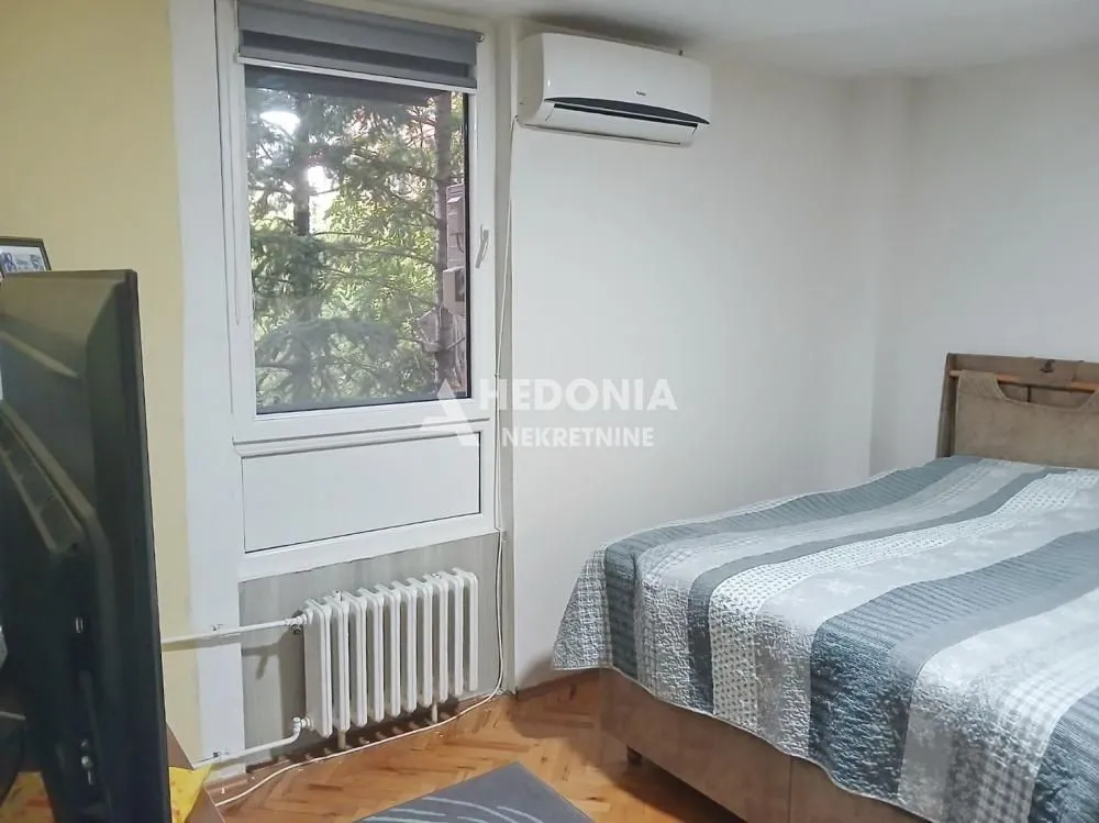 Spavaća soba sa krevetom, prozorom i klima uređajem.