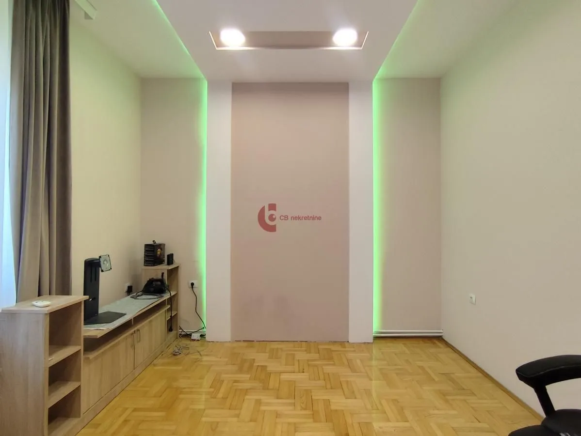 Living room with parquet flooring and decorative wall lighting.