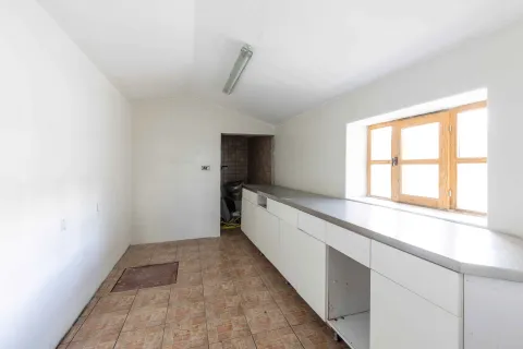 Empty kitchen with white cabinets and a window. - image 35