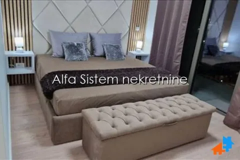 Moderna spavaća soba sa velikim bračnim krevetom, tapaciranim uzglavljem i dekorativnim panelima na zidu. - image 9