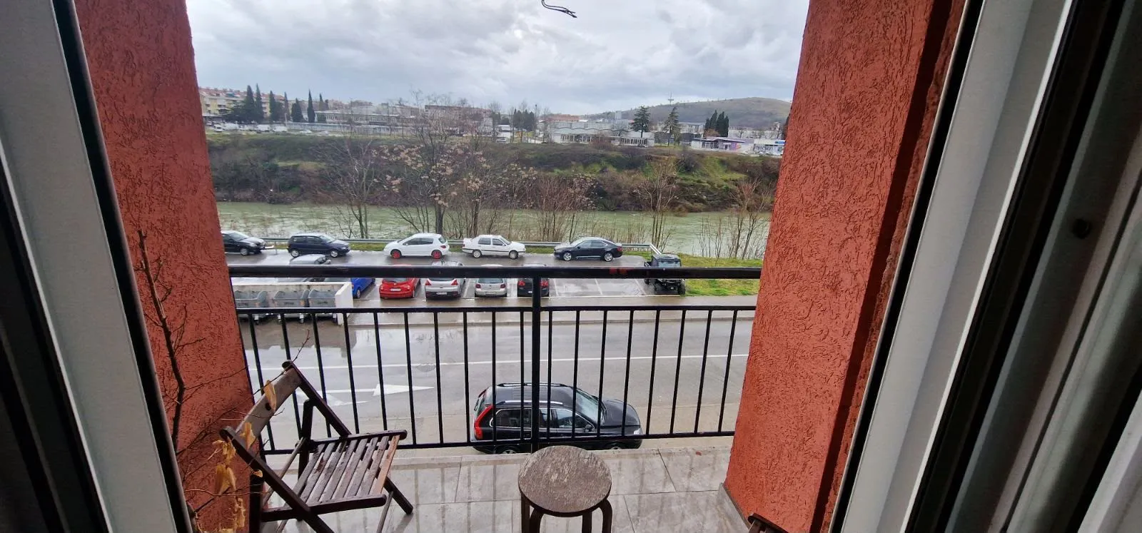 Manji balkon sa pogledom na rijeku, ulicu i parking.