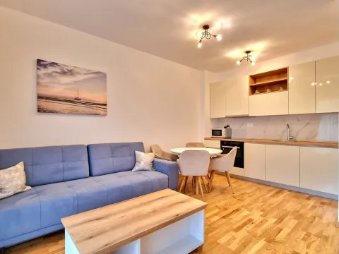 Living room with sofa, dining table, and kitchen. - image 12
