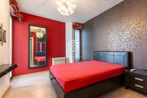 A bedroom with a double bed, a red wall, and decorative wallpaper. - image 11