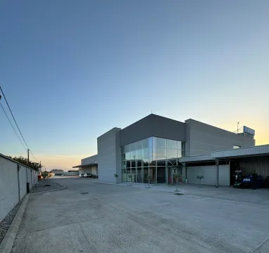 Exterior view of a commercial building with large glass surfaces and driveway. - image 2