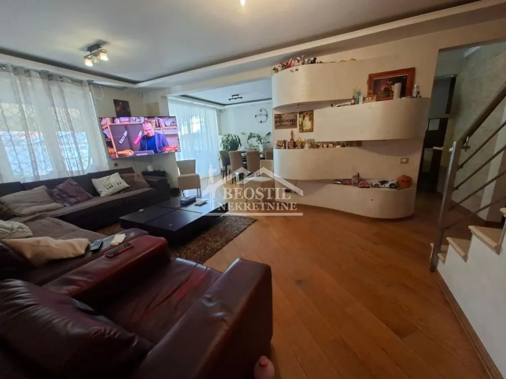 Spacious living room with a seating set and a wall-mounted TV.