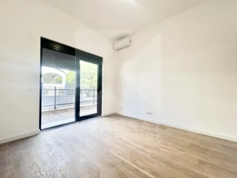 Empty room with wooden flooring, air conditioning unit, and large glass doors leading to the yard. - image 3