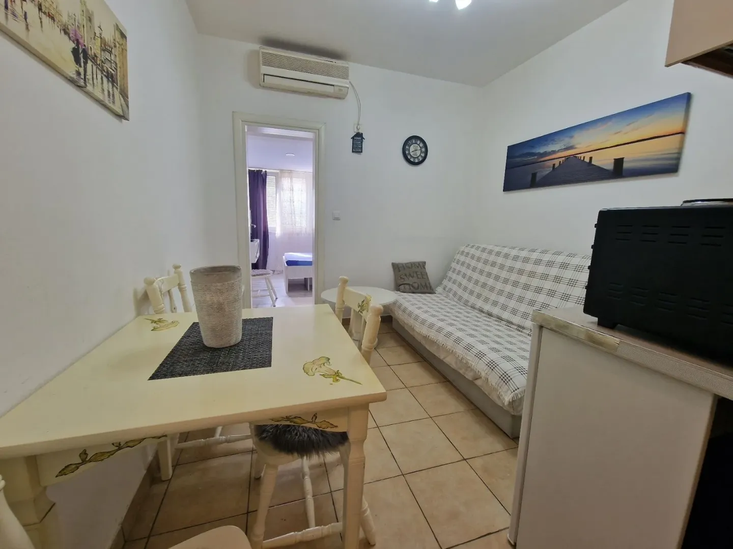 Smaller living room with a dining table and a sofa.
