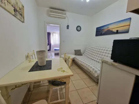 Smaller living room with a dining table and a sofa. - image 14