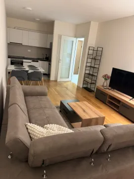 Living room with a sofa and TV, connected to the kitchen and dining area. - image 5