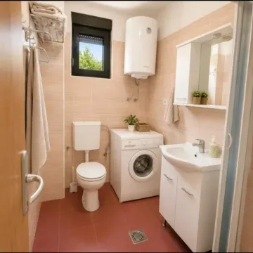 Kupatilo opremljeno sanitarijama, umivaonikom, veš mašinom i bojlerom. - image 8