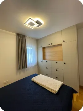 Bedroom with a bed, built-in wardrobe, and a window. - image 4