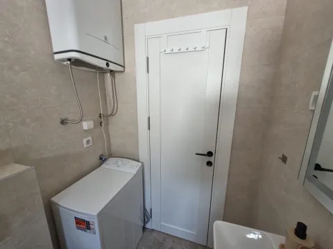Bathroom equipped with plumbing fixtures, a washing machine, and a water heater. - image 8