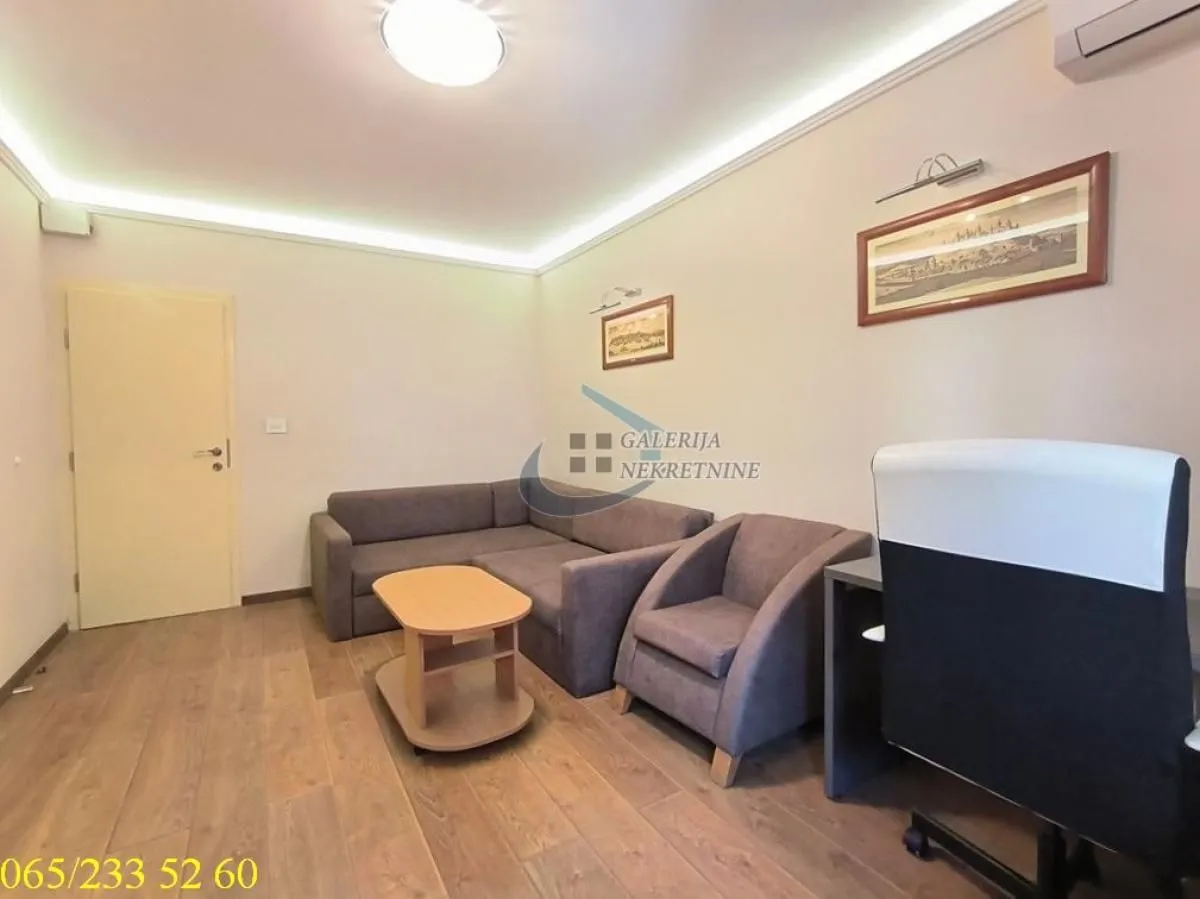 Dnevna soba sa garniturom za sedenje, stočićem i radnim stolom.