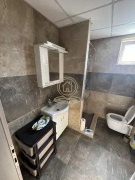Kupatilo obloženo keramičkim pločicama sa umivaonikom, ogledalom i wc šoljom. - image 14