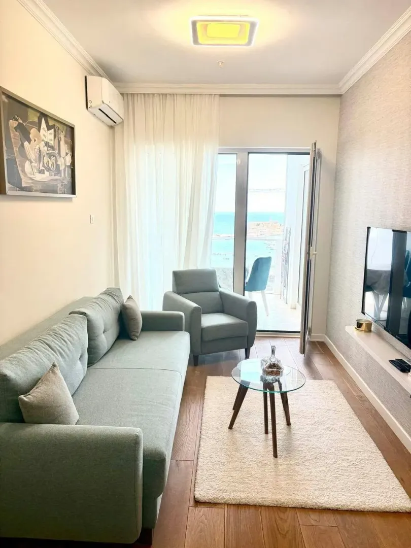 Furnished living room with a sofa and access to a terrace with a sea view.