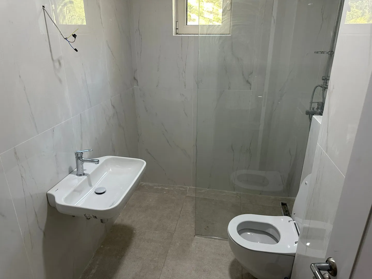 Novoopremljeno kupatilo sa umivaonikom, WC šoljom i tuš kabinom.