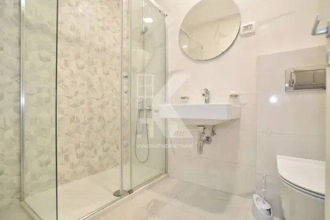 Moderne kupatilo sa tuš kabinom, umivaonikom i okruglim ogledalom. - image 8