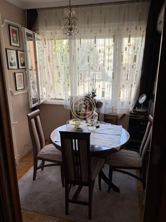 Dining area with a round table, chairs, and a window.