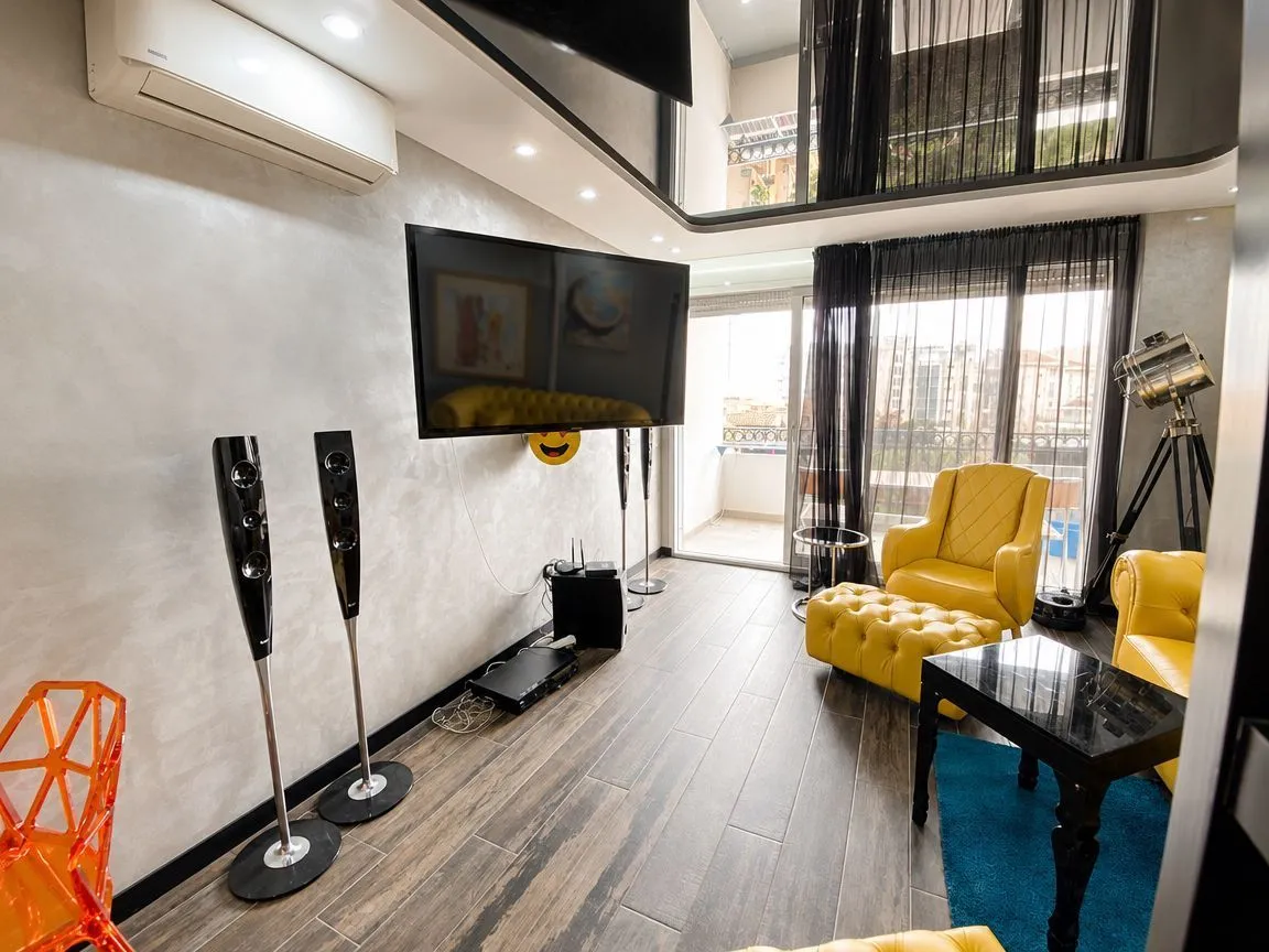 Modern living room with yellow furniture and a wall-mounted TV.