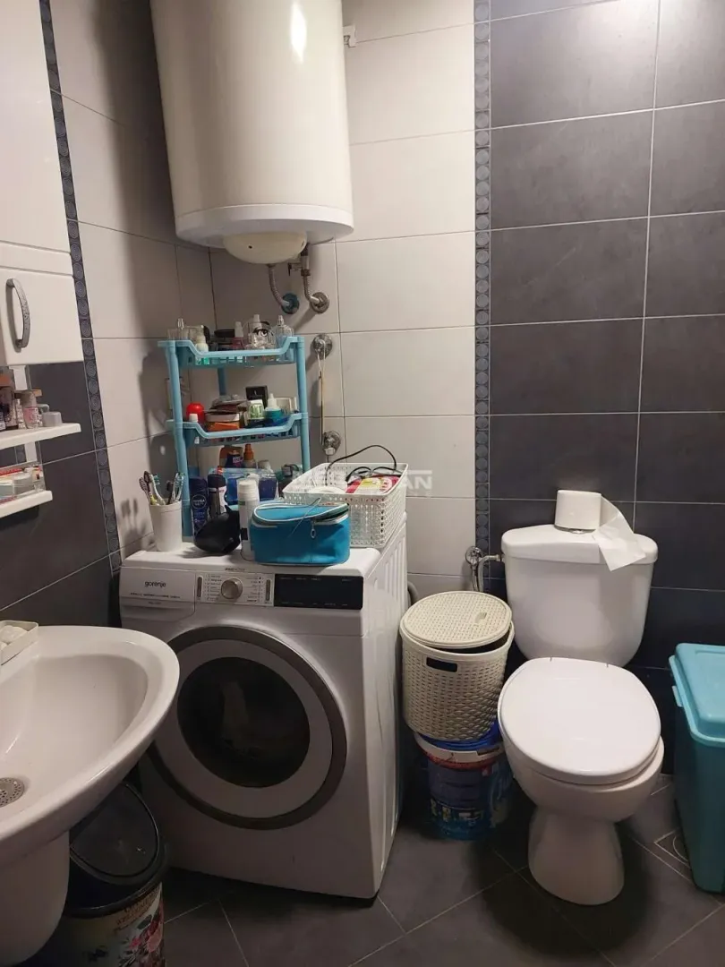 Bathroom equipped with sanitary fixtures, washing machine, and water heater.