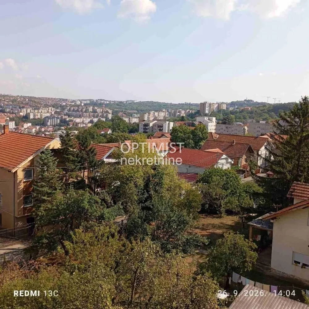 Pogled sa nekretnine na gradsko naselje i okolno zelenilo.