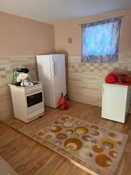 Small kitchen with a stove, refrigerator, and ceramic wall tiles. - image 7