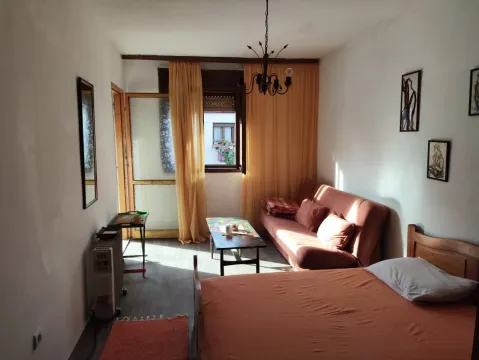 Manja spavaća soba sa krevetom, kaučem i prozorom sa žutim zavjesama. - image 3