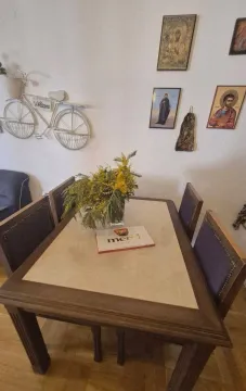 Trpezarijski sto sa stolicama i ukrasnim detaljima na zidu u dnevnom boravku. - image 11