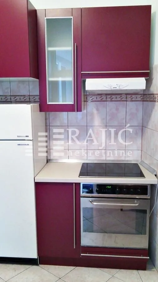 Kitchen with burgundy cabinets and built-in appliances.