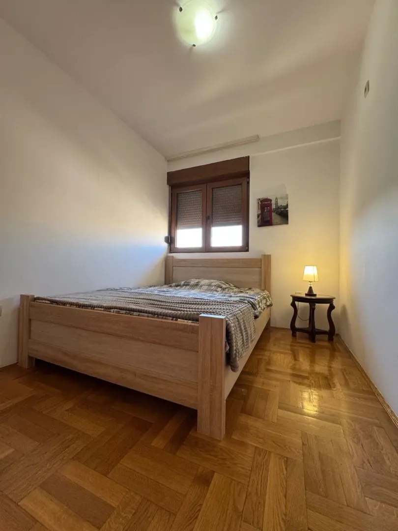 Bedroom with a wooden bed and parquet flooring.