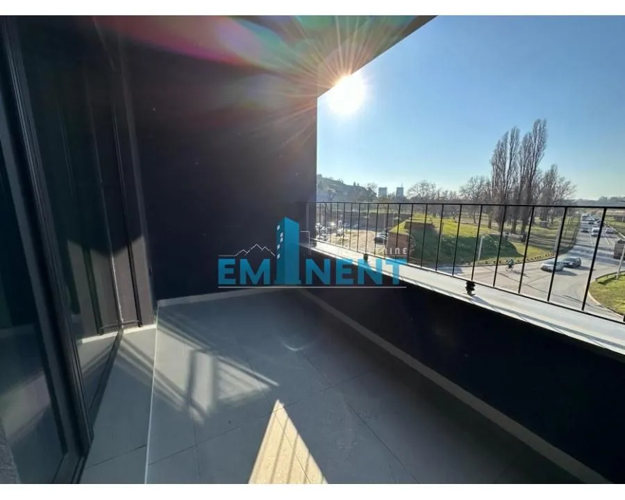 Unfurnished balcony with a view of the street and greenery.