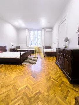 Prostrana spavaća soba sa nekoliko kreveta i drvenim podom. - image 13