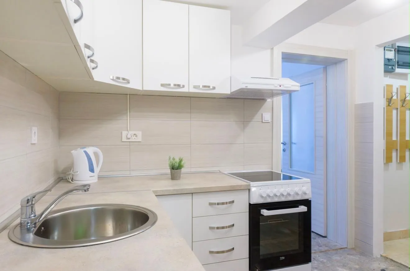 Modern white kitchen with a sink and stove.