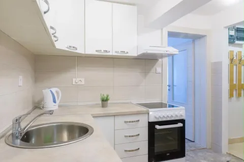 Modern white kitchen with a sink and stove. - image 4