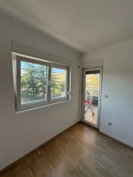 Prazna soba sa parketom, prozorom i balkonskim vratima. - image 10