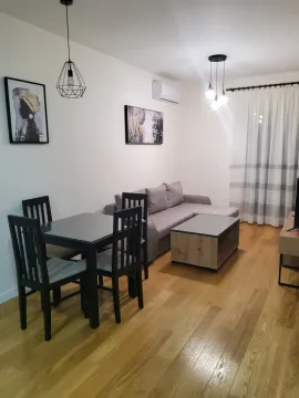 Bright living room with a sectional sofa and a dining table. - image 2