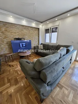 Dnevna soba sa ugaonom garniturom, televizorom i dekorativnim kamenim zidom. - image 5