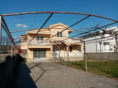 Two-story house with a spacious yard and a metal trellis structure in front of the garage. - image 3