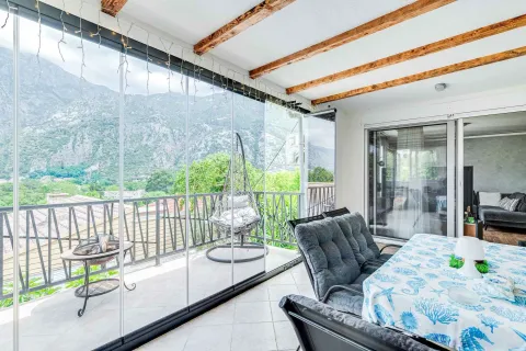 Enclosed terrace with a dining table and mountain view. - image 11