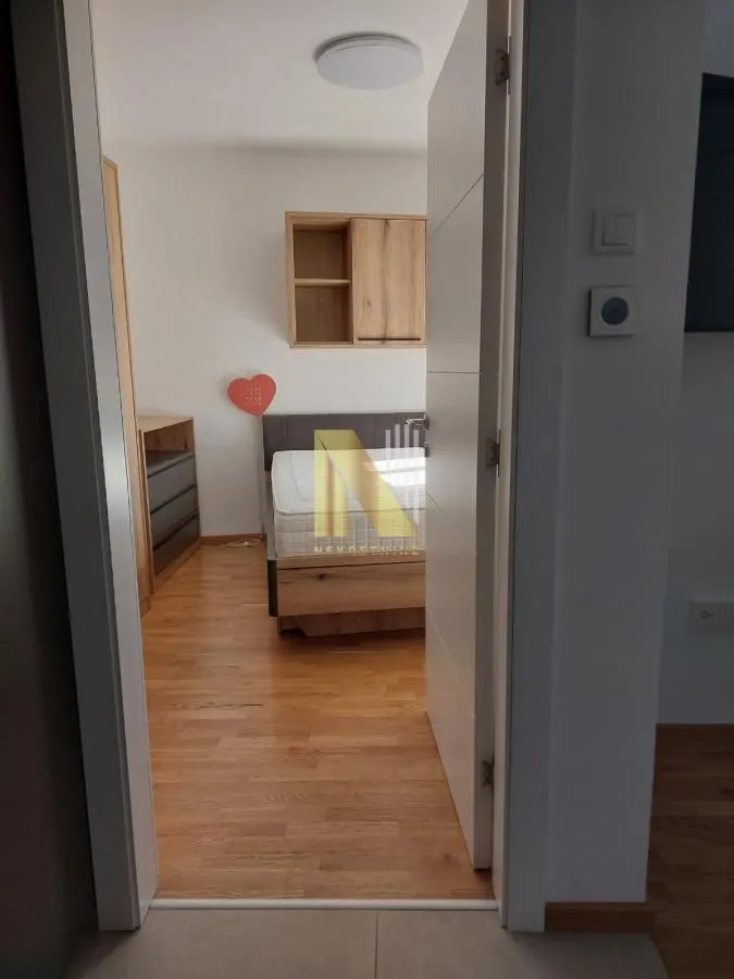 Pogled iz hodnika na nameštenu spavaću sobu.
