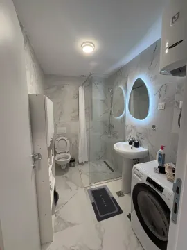 Moderno opremljeno kupatilo sa tuš kabinom, umivaonikom i veš mašinom. - image 5