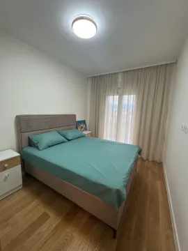 Bedroom with a double bed, white nightstands, and a window with curtains. - image 7