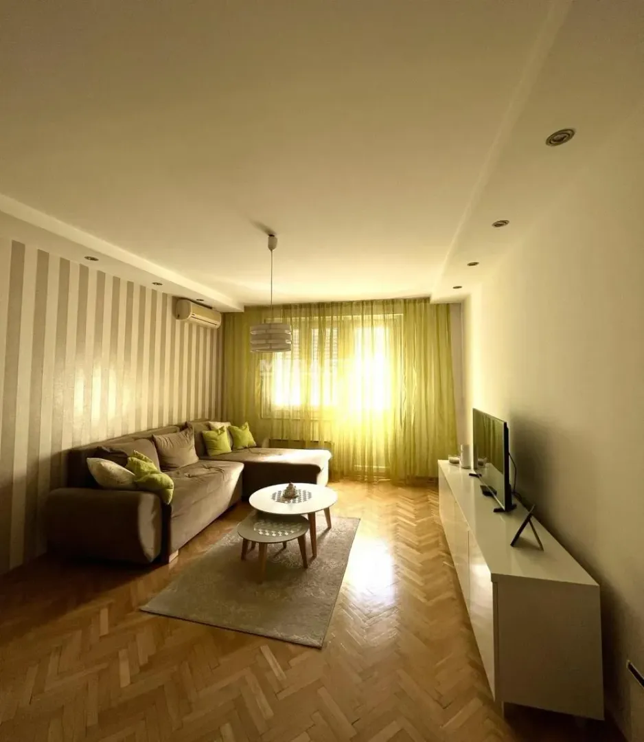 Living room with sofa, coffee table, and television.