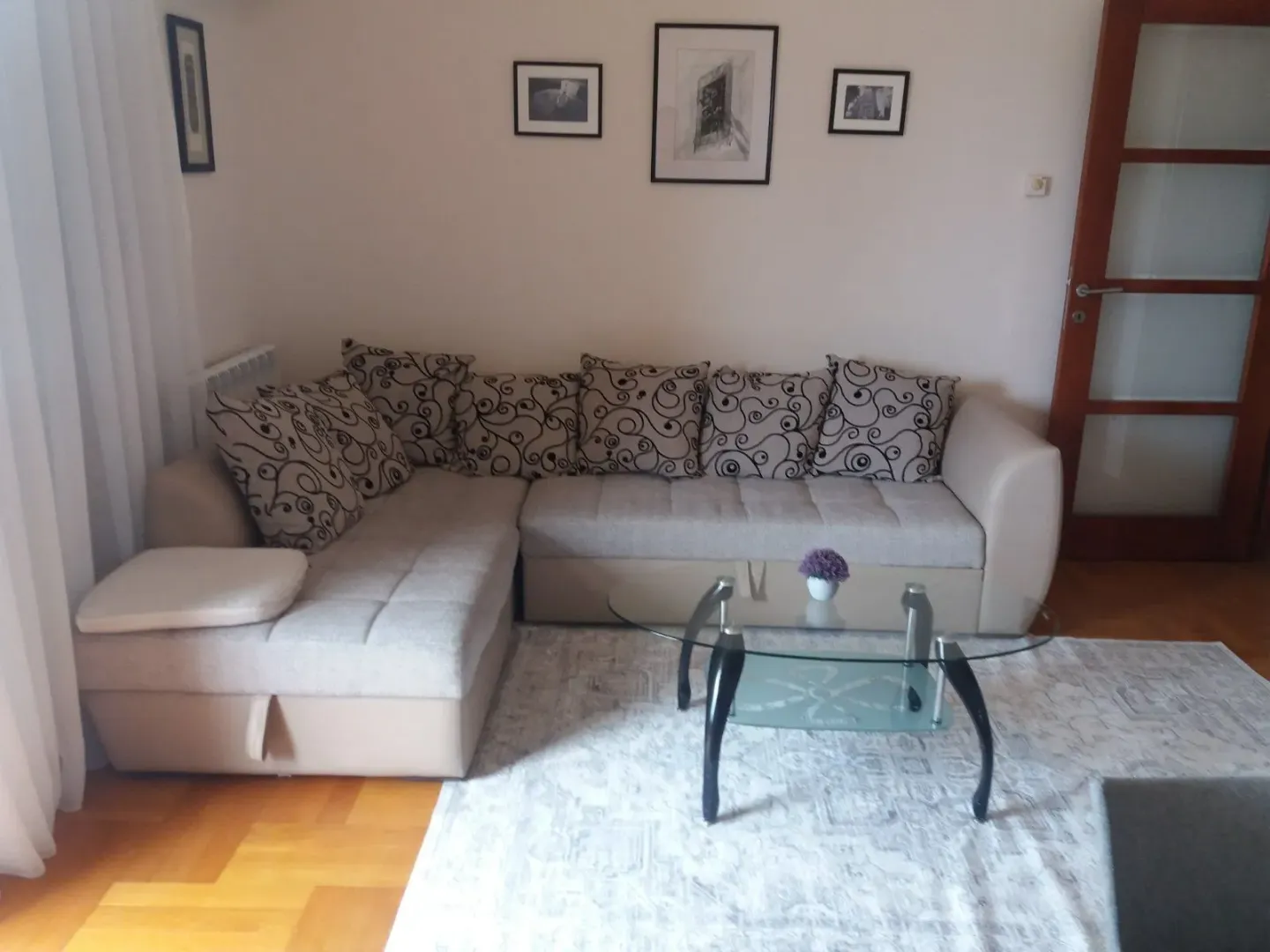 Living room with a corner sofa and a glass coffee table.