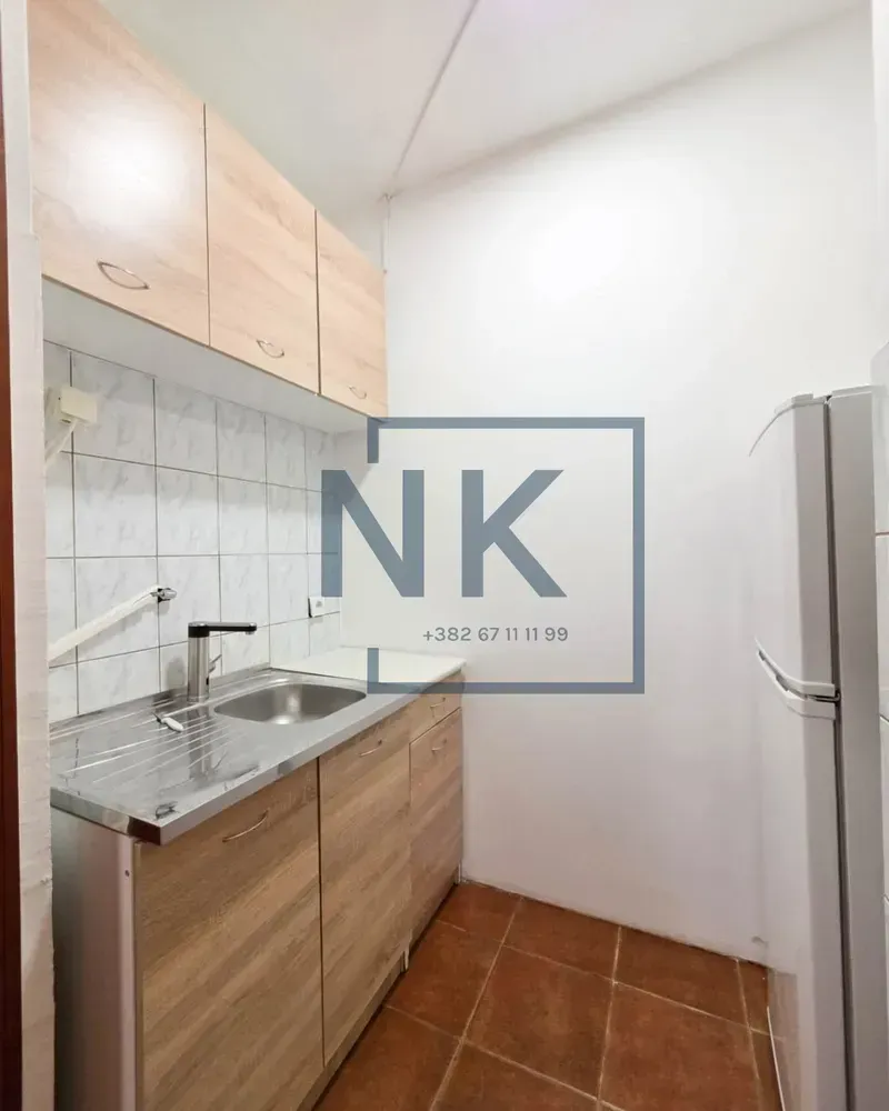 Smaller kitchen with wooden elements and a sink.