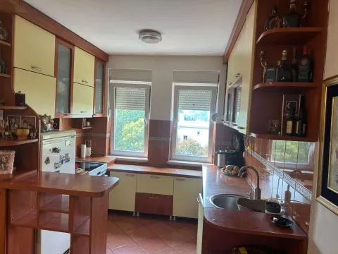 Kuhinja opremljena drvenim elementima i dva prozora. - image 6