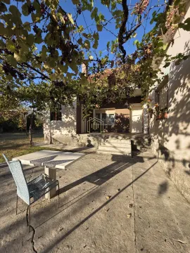 Dvorište kuće sa stolom, stolicom i lozom. - image 17