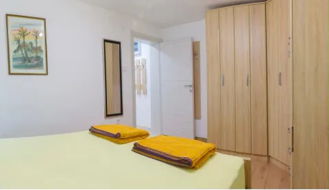 Bright bedroom with a double bed and a large wooden wardrobe. - image 9