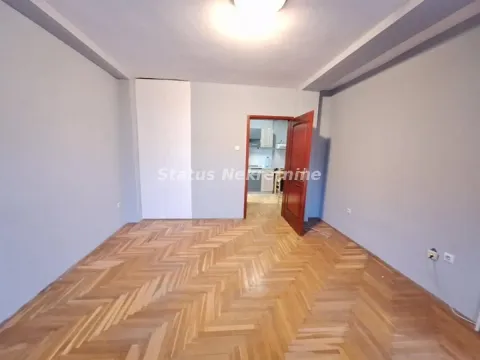 Prazna soba sa parketom i otvorenim vratima prema drugoj prostoriji. - image 2