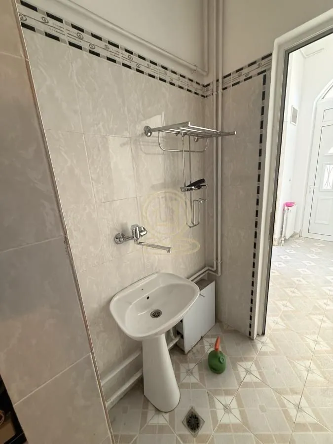 Small tiled bathroom featuring a sink and faucet.